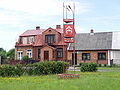 English: the house in Odrowąż center Polski: Odrowąż, domy na północnej pierzei rynku, w środkowym budynku z gankiem przez lata mieścił się miejscowy urząd pocztowy