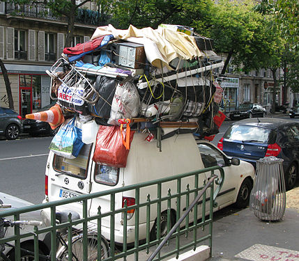 A car, coming back from holidays, with a lot of things on the roof, in Paris