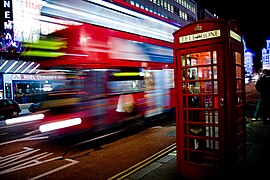 Flou cinétique du bus londonien en mouvement et image nette de la scène, réalisés avec un appareil-photo fixe.