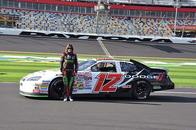 Dufault standing beside her No. 12 car at the ARCA season-opener at Daytona in 2011