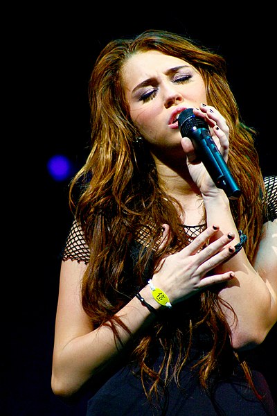 Cyrus singing on her 2009 Wonder World Tour