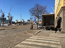 Old person walks in the street to get around truck loading on the sidewalk (41257357385).jpg