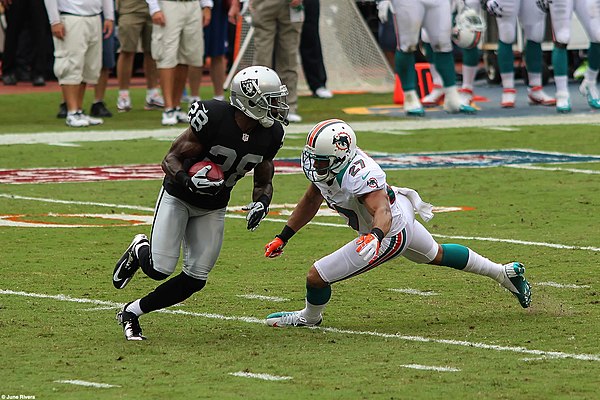 Miami Dolphins cornerback Jimmy Wilson challenges Raiders running back Phillip Adams, September 16