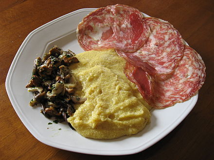 Polenta served with sopressa and mushrooms, a traditional peasant food of Veneto