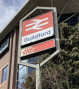 Guildford station sign with Red Star Parcels logo