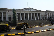 A white building with a triangular facade and wide stairs