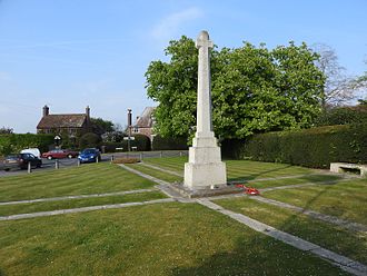 Parallel strips of Portland stone, form a white cross in the lawn, and the tapering Lutyens' War Cross rises from a plinth in the crossing. Sandhurst war memorial 3303.JPG