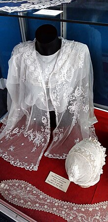 A 100-year-old lace christening cap and dress on display