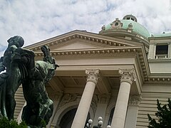 Pórtico e estátua de cavalo, fotografados de baixo