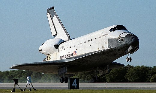 A spaceplane comes in to land at an airport runway.