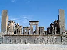 Inscription XPc at Persepolis, on the southern side of the Palace of Darius. It is repeated three times, known as XPca, XPcb and XPcc. XPca and XPcc are facing each other towards the top of the antas (large pillars) on the left and right respectively; both have 15 lines in Old Persian, 14 lines in Elamite and 13 lines in Babylonian. XPcb is on the bottom wall alongside the carvings of Achaemenid soldiers, with 25 lines for each language version; Old Persian is in the middle, Elamite is on the right and Babylonian on the left. Tachar Persepolis Iran.JPG