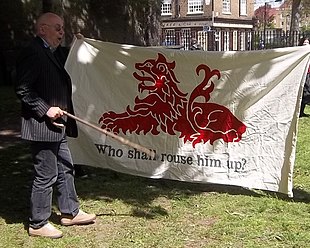 Ian Bone speaking at the installation of the Thomas Rainsborough memorial plaque (12 May 2013), championing Thomas Venner and the Fifth Monarchy Men. The banner is a replica of that used by the insurgents at the time. Who Shall Rouse Him Up.JPG