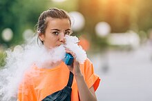 A person exhaling a cloud of aerosol (vapor)