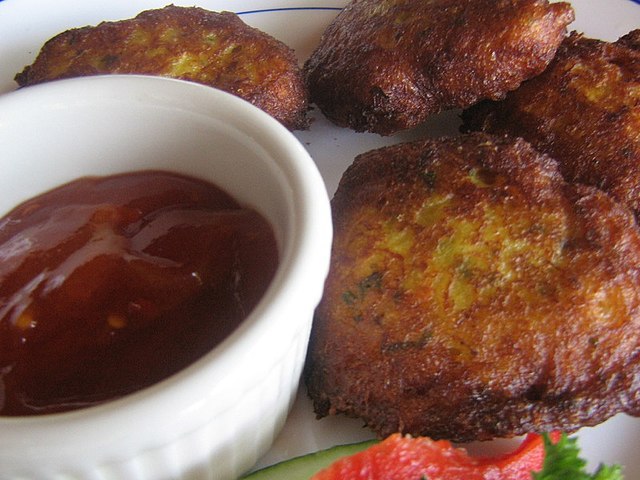 Fritters served with chili sauce in a ramekin
