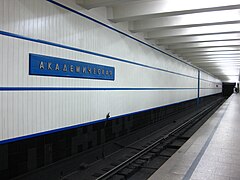 De tunnelwand met aluminiumcomposiet en de stationsnaam