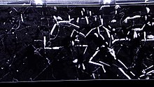 Cloud chambers visualize particles by creating a supersaturated layer of vapor. Particles passing through this region create cloud tracks similar to condensation trails of planes Alpha radiation in a cloud chamber.jpg