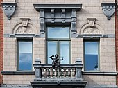 Balcony with a statue of a boy on its balustrade, in Antwerp (Belgium)