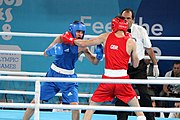 Deutsch: Boxen bei den Olympischen Jugendspielen 2018 Tag 12, 18. Oktober 2018 - Kampf um Bronze im Leichten Weltergewicht Jungen – Hassan Azim (Großbritannien, rot) schlägt Mohammed Boulaouja (Marokko, blau) RSC; Ringrichter ist Wulfren Olivares Peréz (Kolumbien). English: Boxing at the 2018 Summer Youth Olympics on 18 October 2018 – Bronze Medail Match Light Welterweight Boys - Hassan Azim (Great Britain, red) beats Mohammed Boulaouja (Morocco, blue) RSC; Referee is Wulfren Olivares Peréz (Columbia). Español: Boxeo en los Juegos Olímpicos Juveniles de Verano de 2018 en 18 de octubre de 2018 - Medalla de bronce de los hombres ligeros de peso welter: Hassan Azim (Gran Bretaña, rojo) vence a Mohammed Boulaouja (Marruecos, azul) RSC; El árbitro es Wulfren Olivares Peréz (Colombia).