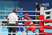 Deutsch: Boxen bei den Olympischen Jugendspielen 2018 Tag 12, 18. Oktober 2018 - Finale Fliegengewicht Mädchen – Martina La Piana (Italien, blau) schlägt Adijat Gbadamosi (Nigeria, rot) 5-0; Ringrichter ist James Beckles (Trinidad und Tobago). English: Boxing at the 2018 Summer Youth Olympics on 18 October 2018 – Girl's flyweight Gold Medal Bout - Martina La Piana (Italy, blue) beats Adijat Gbadamosi (Nigeria, red) 5-0; Referee is James Beckles (Trinidad and Tobago). Español: Boxeo en los Juegos Olímpicos Juveniles de Verano de 2018 en 18 de octubre de 2018 - Combate a medalla de oro de peso mosca para mujeres: Martina La Piana (Italia, azul) le gana a Adijat Gbadamosi (Nigeria, roja) 5-0; El árbitro es James Beckles (Trinidad y Tobago).