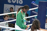 Deutsch: Boxen bei den Olympischen Jugendspielen 2018 Tag 12, 18. Oktober 2018 - Medaillenzeremonie im Fliegengewicht der Mädchen - Gold: Martina La Piana (Italien), Silber: Adijat Gbadamosi (Nigeria), Bronze: Heaven Destiny Garcia (USA); Medaillenübergabe durch Habu Gumel (IOC, Nigeria), Geschenkübergabe durch Dr. Joseph O. Ayeni (Nigeria, AIBA). English: Boxing at the 2018 Summer Youth Olympics on 18 October 2018 – Girl's flyweight Medal Ceremony - Gold: Martina La Piana (Italy), Silver: Adijat Gbadamosi (Nigeria), Bronze: Heaven Destiny Garcia (USA); Medal handover by Habu Gumel (IOC, Nigeria), Gift presented by Dr. Joseph O. Ayeni (Nigeria, AIBA). Español: Boxeo en los Juegos Olímpicos Juveniles de Verano de 2018 en 18 de octubre de 2018 - Ceremonia de la Medalla de peso mosca para niñas - Oro: Martina La Piana (Italia), Plata: Adijat Gbadamosi (Nigeria), Bronce: Heaven Destiny Garcia (Estados Unidos); Entrega de medallas por Habu Gumel (COI, Nigeria), Regalo presentado por Joseph O. Ayeni (Nigeria, AIBA).