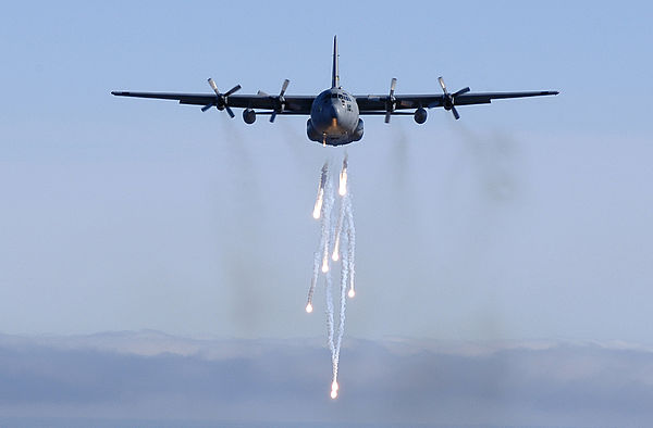 A Michigan Air National Guard C-130E dispatches its flares during a low-level training mission