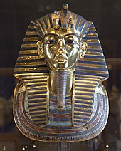 Photographie d'un masque doré représentant le visage du pharaon.