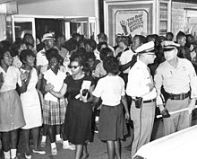 African American women participate in Civil Rights protest in Tallahassee, Florida, 1963 Civil rights demonstration in front of a segregated theater Tallahassee, Florida (6847006931).jpg