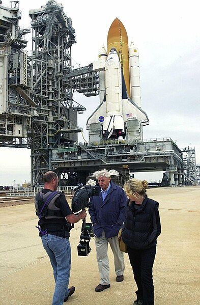 Attenborough filming commentary for a documentary at the Kennedy Space Center in Florida, with a Space Shuttle in the background