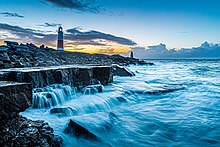 Portland Bill Lighthouse at dawn with Trinity House Landmark in the distance Portland Bill Lighthouse, dawn 6.19 am.jpg