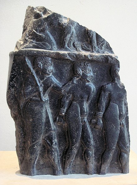 Prisoners escorted by a soldier, on a victory stele of Sargon of Akkad, circa 2300 BC.[35][36] The hairstyle of the prisoners (curly hair on top and short hair on the sides) is characteristic of Sumerians, as also seen on the Standard of Ur.[37] Louvre Museum.