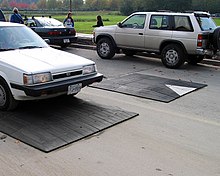 Speed cushions in Canada. Gaps allow wide-track emergency vehicles to pass at higher speeds than they can through other traffic calming devices like speed humps. Rubber speed cushions.jpg