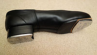 Side view of tap shoe, showing taps mounted to bottoms of heel and toe