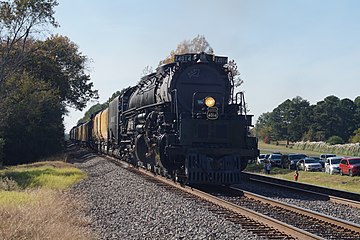 An articulated steam locomotive pulling a passenger train