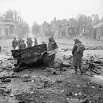 Soldados aliados checam a carcaça de um blindado alemão destruído em Tilly-sur-Seulles, nas cercanias de Caen.