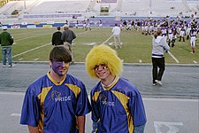 Members of the UNA Lion Pride spirit team sporting the traditional school colors, purple and gold. The team, begun in 2007, is charged with generating school spirit not only on the athletic field but also on campus. UNA-Fans.jpg