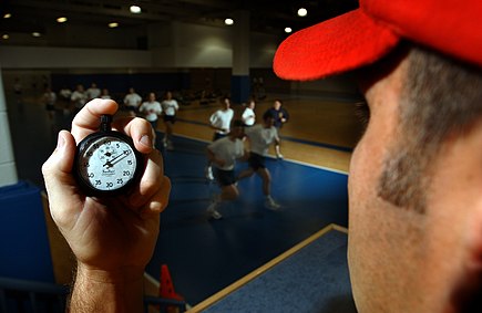 US Navy 030506-N-5862D-128 An instructor in the Freedom Hall athletic complex uses a stopwatch while recruits run a 1.5-mile track during a Physical Fitness Test (PFT).jpg