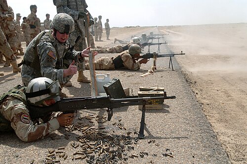 US Navy 060427-N-8252B-114 Commander, of Company B, 2nd Battalion, 8th Infantry Regiment, 2nd Brigade Combat Team, 4th Infantry Division, Capt. Colin Brooks, helps an Iraqi Army soldier fire rounds down range during a training.jpg