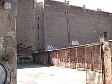 Garagenlandschaft mit Brandmauer der dahinter befindlichen Mietskaserne (in der John-Schehr-Straße), 2007