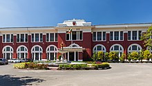 Die Faculty of Medicine of University of Rangoon. Ein langgestrecktes, zweistöckiges Gebäude mit Rundbogenfenstern im Erdgeschoss.