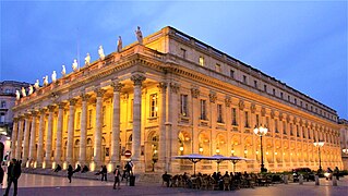 Photographie du Grand-Théâtre de nuit illuminé par des lumières jaunes.
