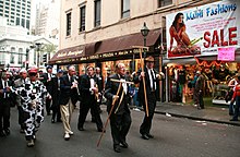 New Orlean's Cowbellion de Rakin Society parading with rakes and cowbells down Canal Street in 2007. CowbellionsRoyalCanal2007.jpg