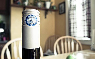 Capsule congé bleue sur une bouteille de vin avec un bouchon à visser.