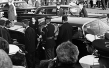 Jacqueline Kennedy, standing near Robert F. Kennedy, about to enter her 1960 Imperial Crown limousine after the funeral of President John F. Kennedy at St. Matthew's Cathedral JFK funeral - Jacqueline & Robert Kennedy entering limousine.png