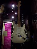 A color photograph of a white Fender Stratocaster guitar