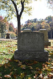 A grey stone headstone marked McNair, William Nissey 1880-1948 Husband.