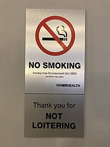 Sign informing people of New South Wales' smoking ban NSW Health No Smoking sign above No Loitering sign.jpg