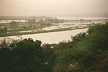 the Niger River from southern Niamey, with the Kennedy Bridge in the distance. Seasonally shallow and broken by rapids, the river is difficult for large boats to navigate. NigerNiamey.jpg