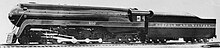 A black-and-white image of a streamlined steam locomotive and tender