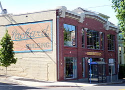 Photograph of the Packard Service Building, a two-story brick building with a large Packard text mural on the side