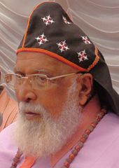 Photograph of an old man with white beard wearing glasses.